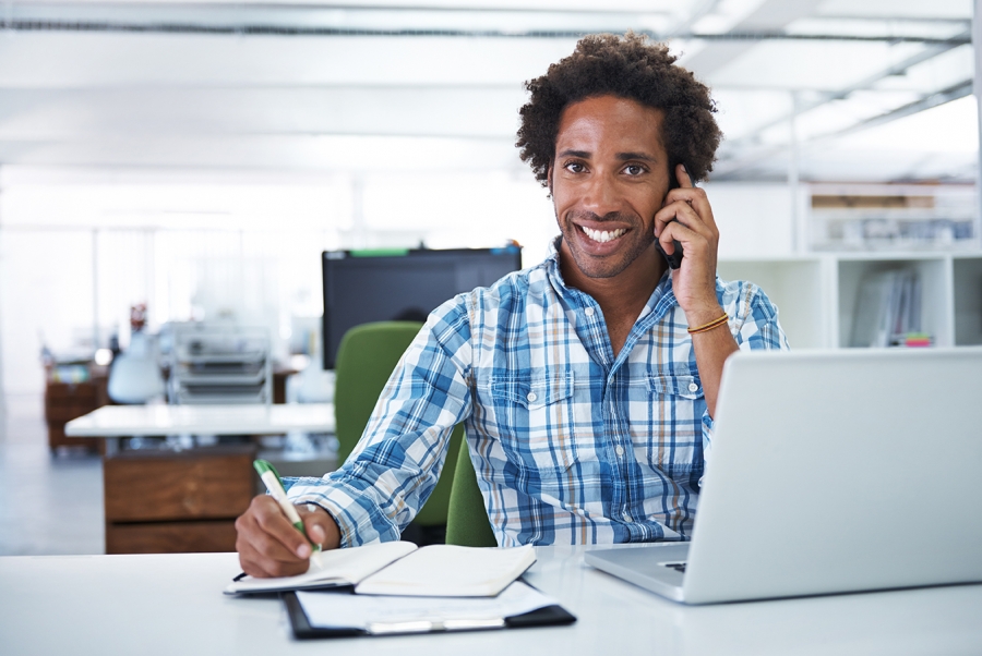 Man sitting in front of laptop talking on the phone
