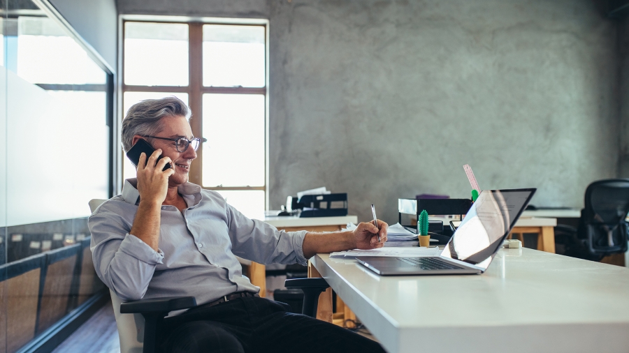 Working in the office Man on the phone working at his desk