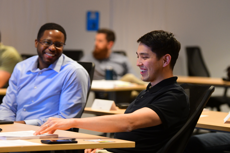 Two men in a training room having a conversation