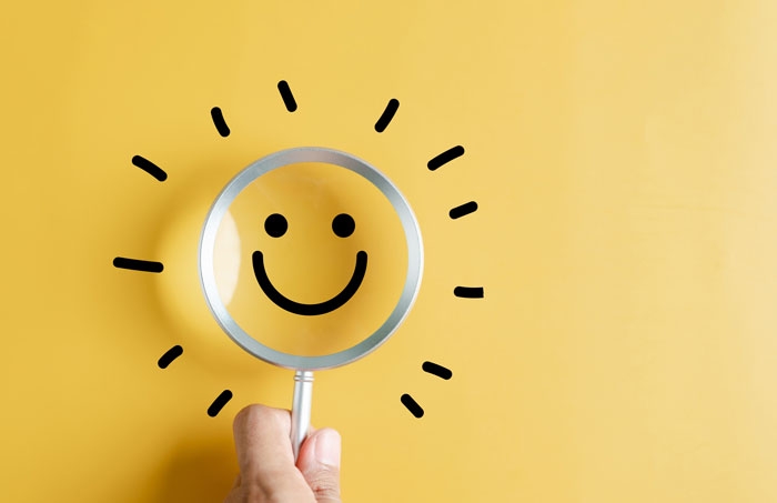 A magnifying glass with a smiley face through it