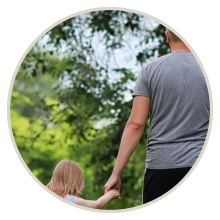 A father and daughter holding hands while walking