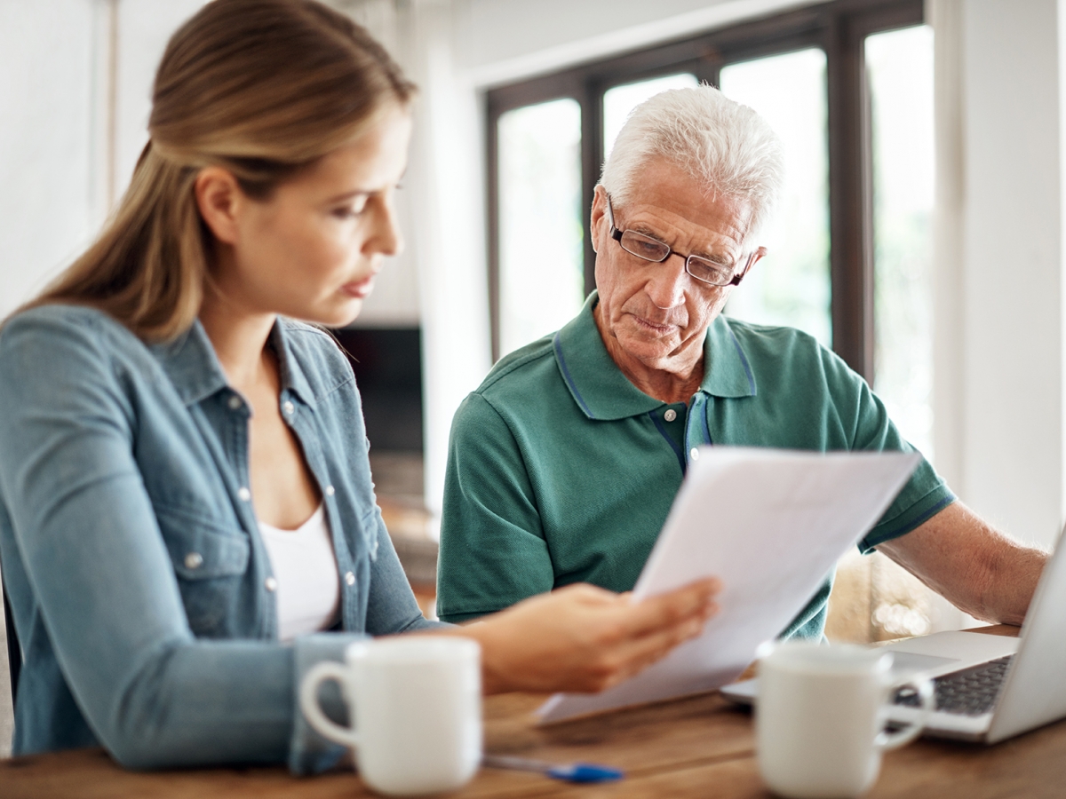 Father and daughter looking at a bill