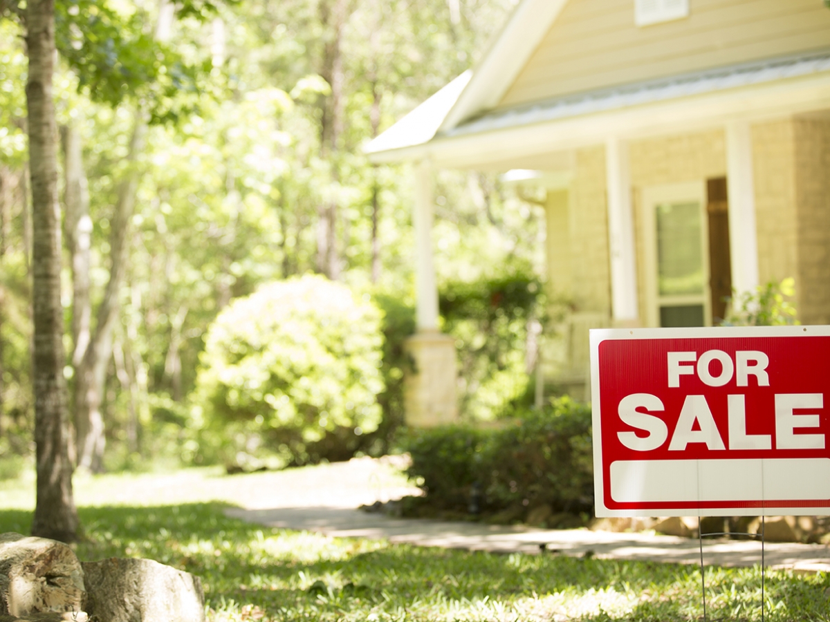 House with a for sale sign out front