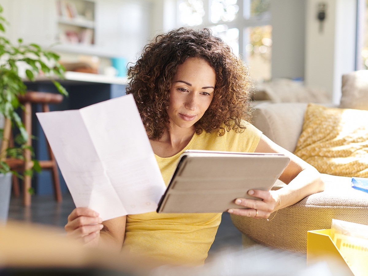 Reading Your Bill Woman looking at her tablet while holding a bill