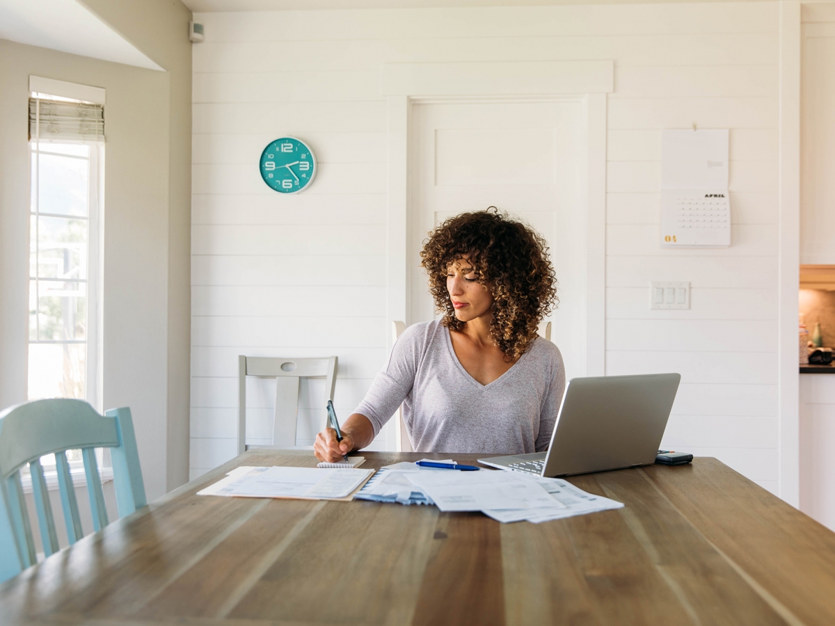 View Your Bill Woman working at a kitchen table
