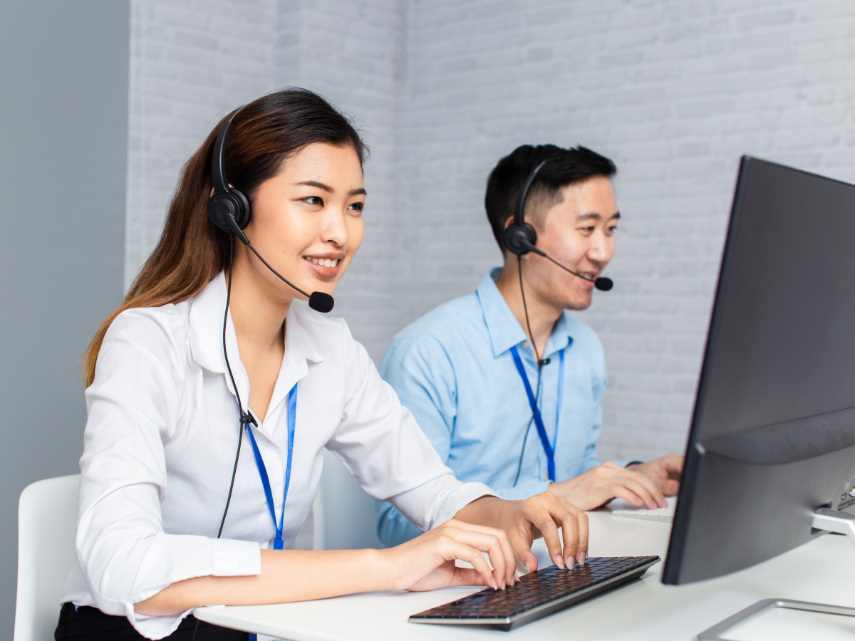 Two customer service representatives typing on keyboards on Live Chat