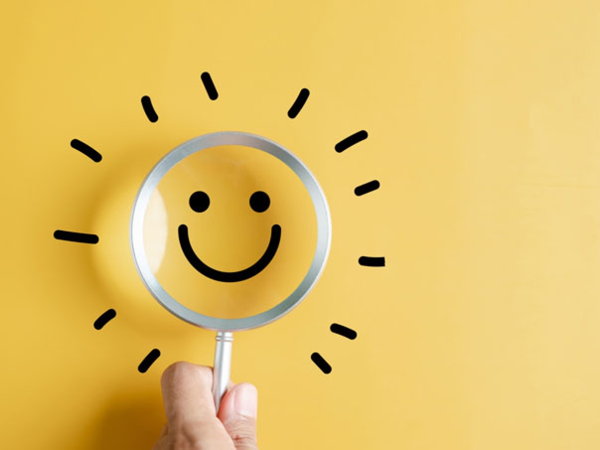A magnifying glass with a smiley face through it