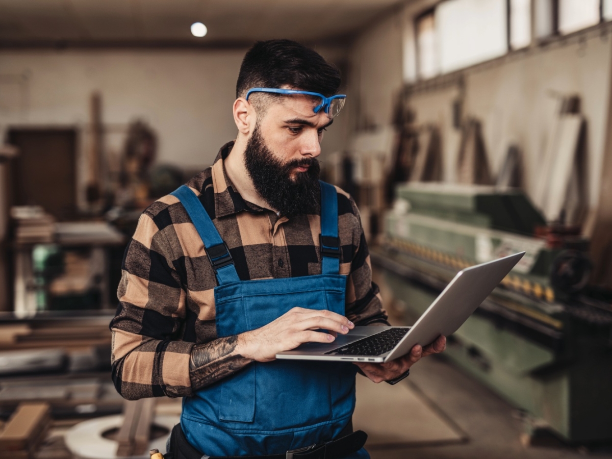 man with laptop in workshop